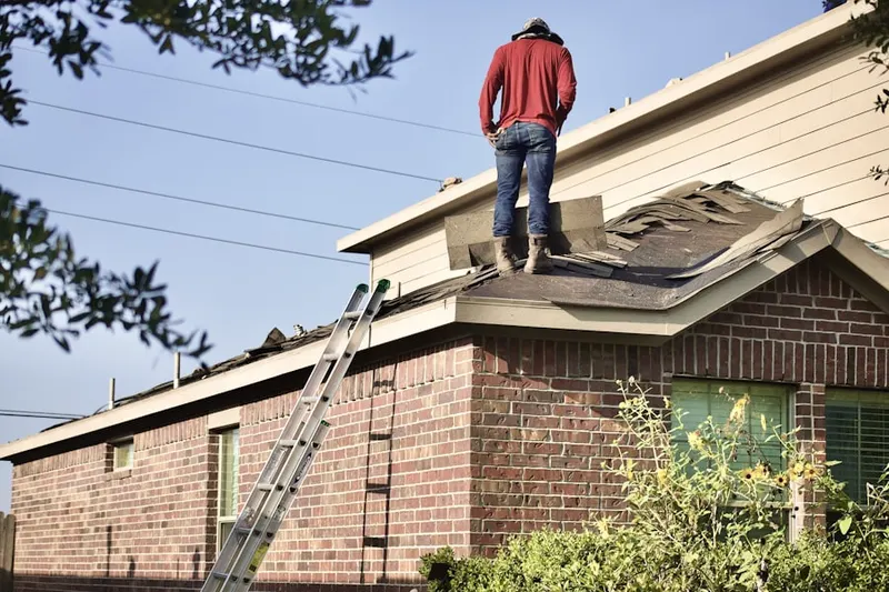 Professional roofer working on a residential roof in Webster City